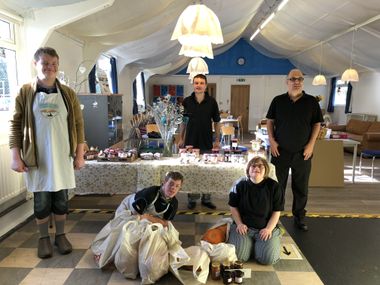 Five people at Swallow cafe receiving bags of donated vegetables.